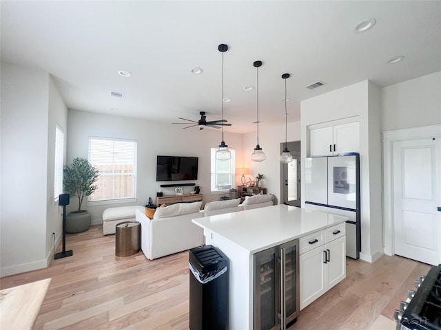 5402 Wheatley St Unit D, Houston, TX 77091 - kitchen featuring freestanding refrigerator, beverage cooler, ceiling fan, light wood finished floors, and white cabinetry