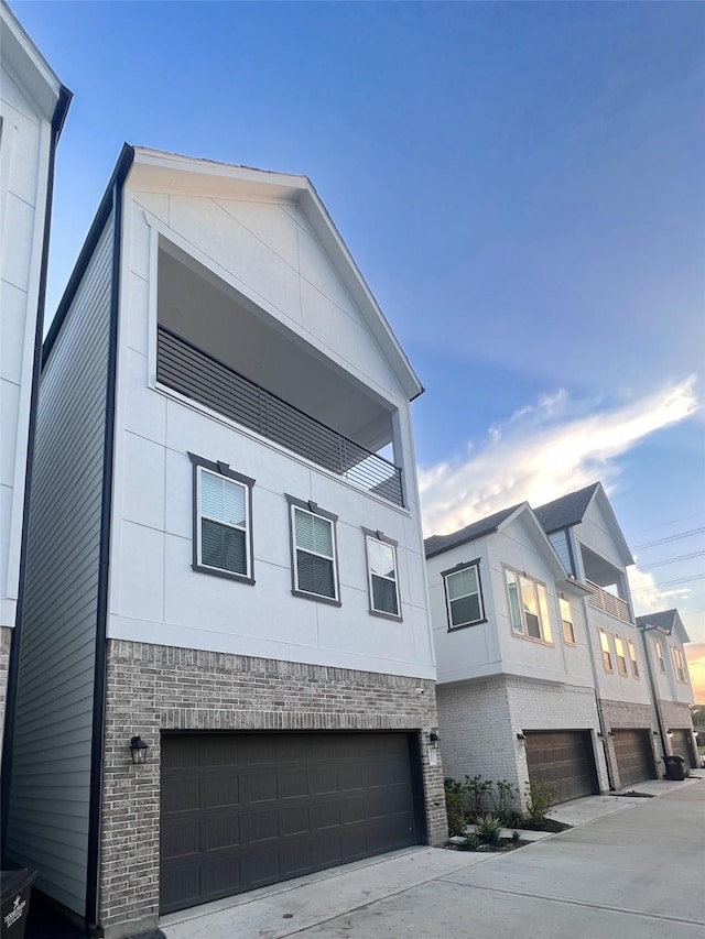 5402 Wheatley St Unit D, Houston, TX 77091 - view of front of property with a garage, brick siding, a balcony, and driveway