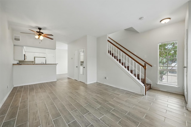 2626 Holly Hall St Unit 1102, Houston, TX 77054 - unfurnished living room with a ceiling fan, wood finished floors, stairs, and baseboards