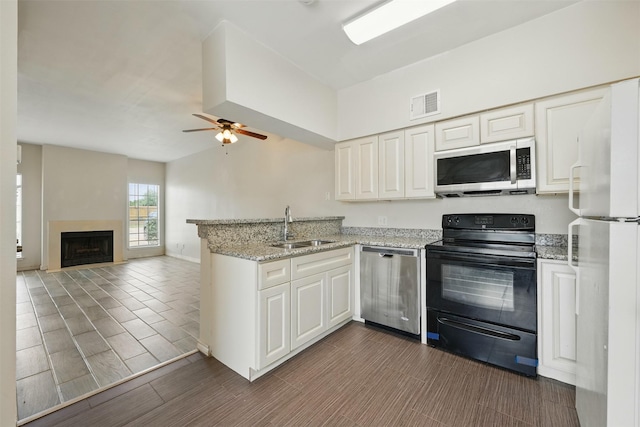 2626 Holly Hall St Unit 1102, Houston, TX 77054 - kitchen featuring appliances with stainless steel finishes, a peninsula, a sink, and white cabinetry