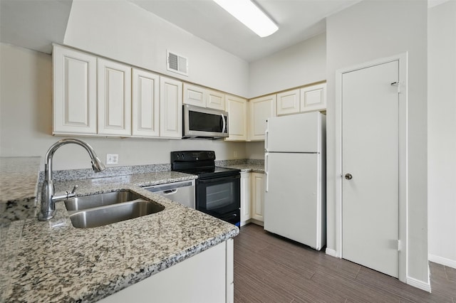 2626 Holly Hall St Unit 1102, Houston, TX 77054 - kitchen with appliances with stainless steel finishes, a sink, light stone countertops, dark wood finished floors, and baseboards
