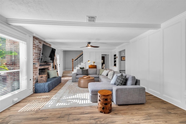 16310 Sir William Dr, Spring, TX 77379 - living area featuring plenty of natural light, beam ceiling, stairway, a decorative wall, and wood finished floors