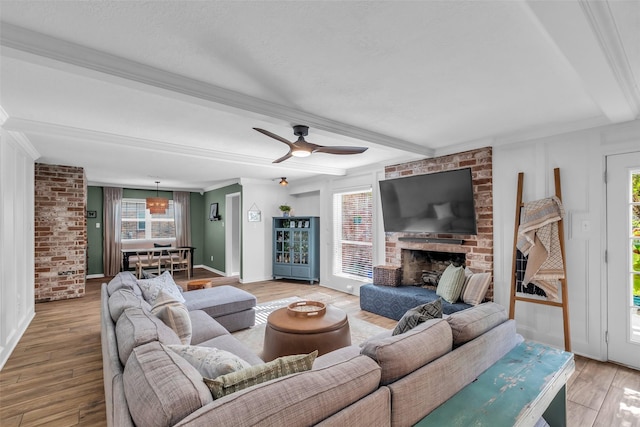 16310 Sir William Dr, Spring, TX 77379 - living area with beamed ceiling, light wood-style flooring, a ceiling fan, a brick fireplace, and brick wall
