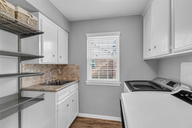 16310 Sir William Dr, Spring, TX 77379 - laundry area featuring washer and dryer, baseboards, wood finished floors, and cabinet space
