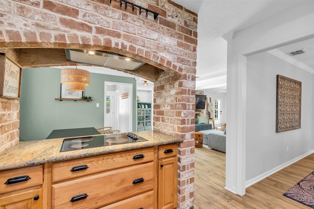 16310 Sir William Dr, Spring, TX 77379 - kitchen with black electric stovetop, light wood-style flooring, ornamental molding, arched walkways, and wall chimney exhaust hood