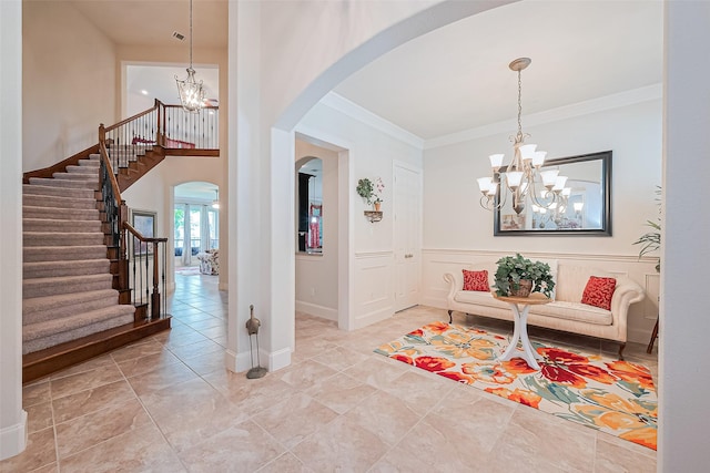 11907 Wind Cove Place Ct, Humble, TX 77346 - entryway featuring a chandelier, arched walkways, ornamental molding, stairway, and baseboards