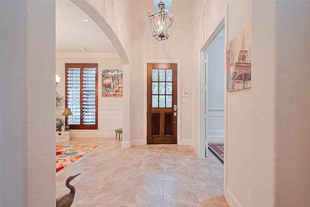 11907 Wind Cove Place Ct, Humble, TX 77346 - entrance foyer with arched walkways, crown molding, and a chandelier