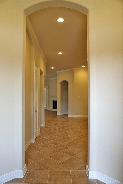 4914 Ava Meadows Ln, Sugar Land, TX 77479 - hallway with arched walkways, recessed lighting, tile patterned flooring, crown molding, and baseboards