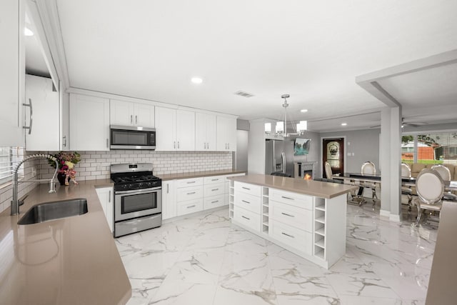 2701 Oaks Dr, Pasadena, TX 77502 - kitchen featuring appliances with stainless steel finishes, a sink, recessed lighting, decorative backsplash, and white cabinetry