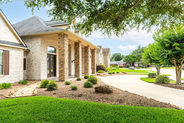 51 Northwood Ct, Lake Jackson, TX 77566 - view of property exterior featuring a shingled roof and brick siding