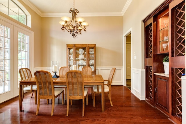 51 Northwood Ct, Lake Jackson, TX 77566 - dining area featuring a chandelier, ornamental molding, dark wood-type flooring, wainscoting, and a decorative wall