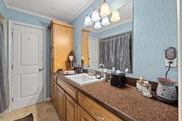 3026 Beluche Dr, Galveston, TX 77551 - full bathroom with crown molding, vanity, and a chandelier