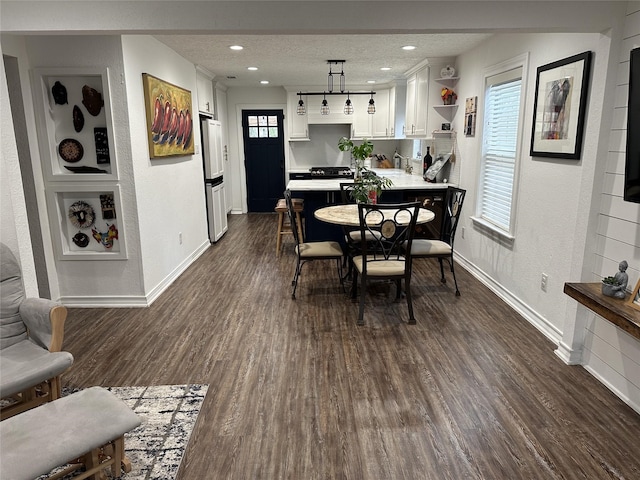 2044 Des Jardines St, Houston, TX 77023 - dining space featuring healthy amount of natural light, dark wood finished floors, a textured wall, baseboards, and a textured ceiling
