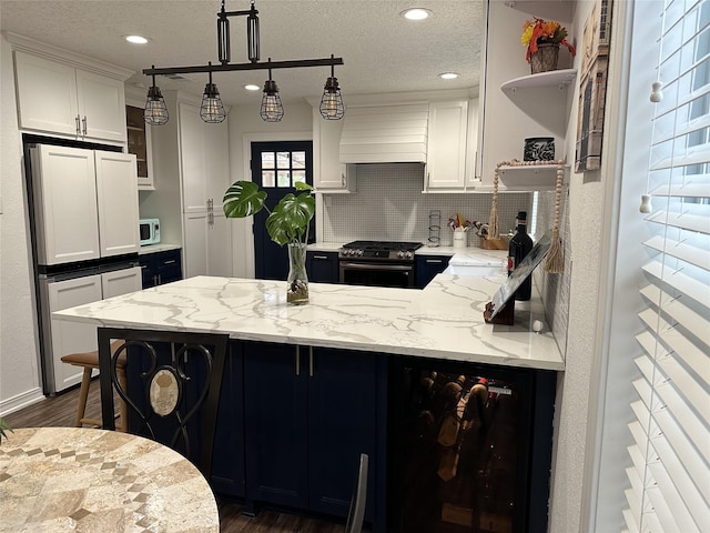 2044 Des Jardines St, Houston, TX 77023 - kitchen with open shelves, stainless steel range with gas stovetop, a peninsula, premium range hood, and paneled built in fridge