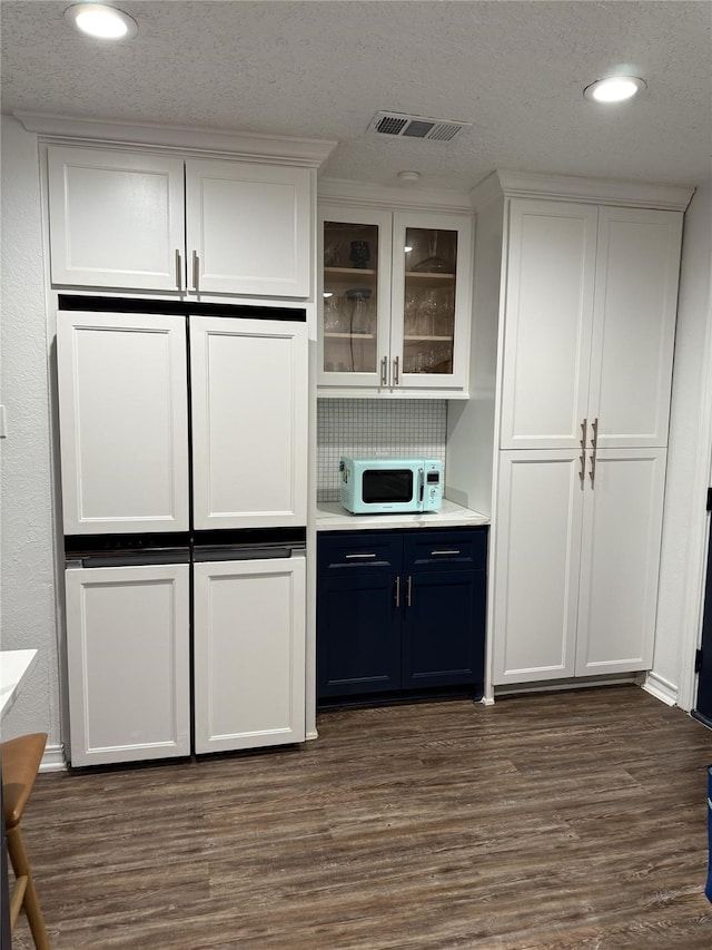 2044 Des Jardines St, Houston, TX 77023 - bar with white microwave, dark wood-style flooring, recessed lighting, and backsplash