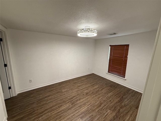 2044 Des Jardines St, Houston, TX 77023 - empty room with dark wood finished floors, a textured ceiling, and baseboards