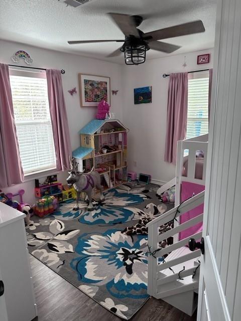 2044 Des Jardines St, Houston, TX 77023 - bedroom with multiple windows, wood finished floors, and a ceiling fan