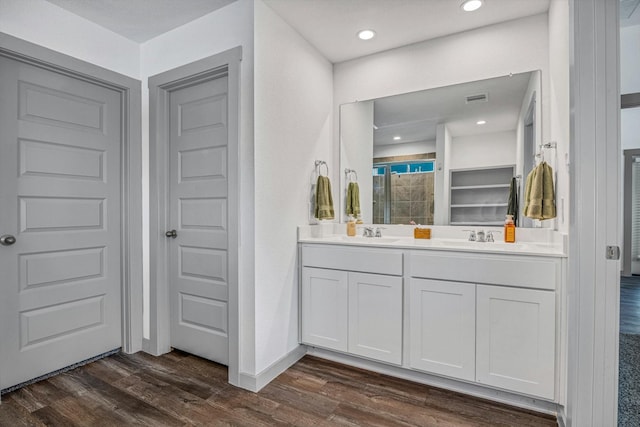 1709 Perch St, Alvin, TX 77511 - full bathroom featuring wood finished floors, double vanity, a tile shower, baseboards, and recessed lighting