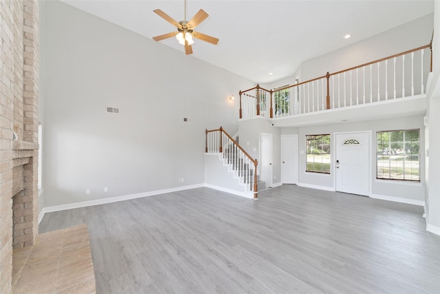 14651 Via Del Norte Dr, Houston, TX 77083 - unfurnished living room featuring high vaulted ceiling, stairs, ceiling fan, wood finished floors, and baseboards
