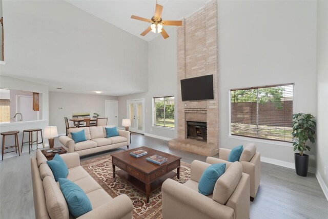 14651 Via Del Norte Dr, Houston, TX 77083 - living room with high vaulted ceiling, wood finished floors, a ceiling fan, baseboards, and a fireplace