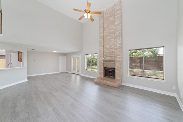 14651 Via Del Norte Dr, Houston, TX 77083 - unfurnished living room with high vaulted ceiling, ceiling fan, a fireplace, baseboards, and wood finished floors