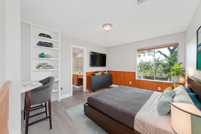 14651 Via Del Norte Dr, Houston, TX 77083 - bedroom with a desk, light wood-style flooring, and wooden walls