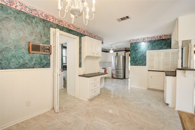 10902 Brentway Dr, Houston, TX 77070 - kitchen featuring freestanding refrigerator, wallpapered walls, dark countertops, wainscoting, and a chandelier
