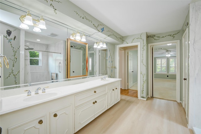 10902 Brentway Dr, Houston, TX 77070 - bathroom with double vanity, wood finished floors, a stall shower, and wallpapered walls