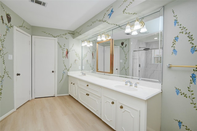 10902 Brentway Dr, Houston, TX 77070 - full bathroom featuring wood finished floors, double vanity, a chandelier, a walk in shower, and wallpapered walls