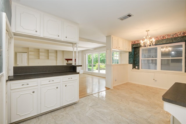 10902 Brentway Dr, Houston, TX 77070 - kitchen with a chandelier, dark countertops, white cabinets, and hanging light fixtures