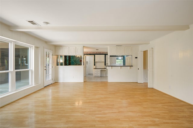 10902 Brentway Dr, Houston, TX 77070 - unfurnished living room with beamed ceiling, light wood-style floors, and healthy amount of natural light