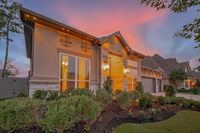 17414 Orchid Falls Ln, Conroe, TX 77302 - view of front facade featuring stone siding, an attached garage, stucco siding, and driveway