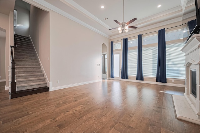 17414 Orchid Falls Ln, Conroe, TX 77302 - unfurnished living room featuring ceiling fan, a glass covered fireplace, arched walkways, wood finished floors, and recessed lighting
