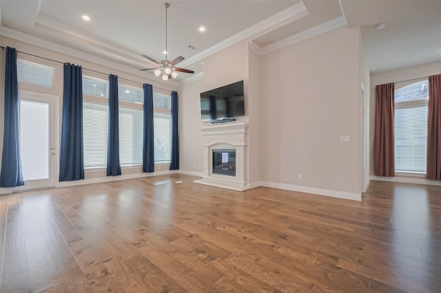 17414 Orchid Falls Ln, Conroe, TX 77302 - unfurnished living room with a ceiling fan, ornamental molding, wood finished floors, a glass covered fireplace, and baseboards