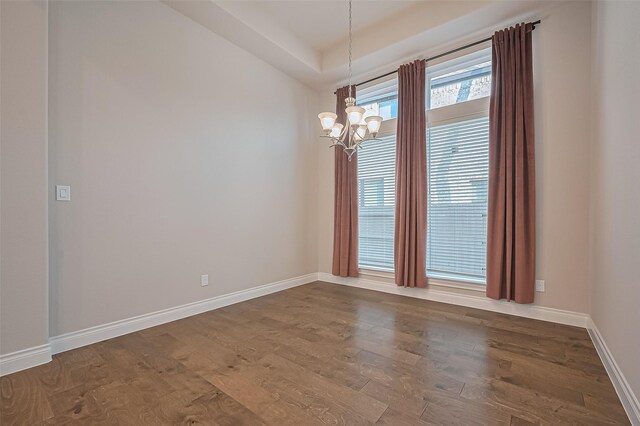 17414 Orchid Falls Ln, Conroe, TX 77302 - unfurnished room with a chandelier, dark wood-style floors, a raised ceiling, and baseboards