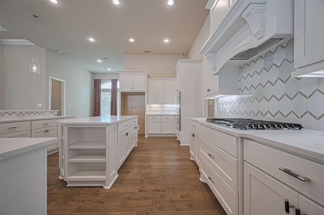17414 Orchid Falls Ln, Conroe, TX 77302 - kitchen featuring white cabinets, decorative backsplash, stainless steel gas stovetop, hanging light fixtures, and dark wood-type flooring
