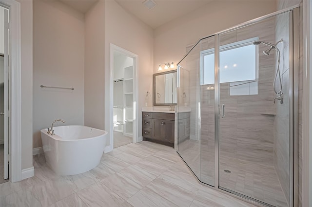 17414 Orchid Falls Ln, Conroe, TX 77302 - bathroom featuring vanity, a shower stall, a freestanding tub, a walk in closet, and baseboards