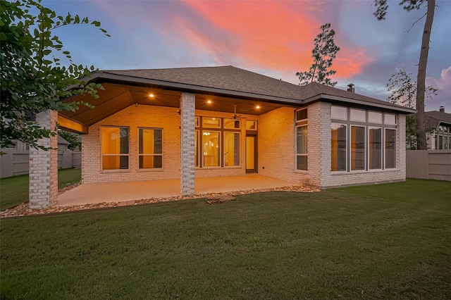 17414 Orchid Falls Ln, Conroe, TX 77302 - back of property at dusk featuring brick siding, a patio area, and a shingled roof