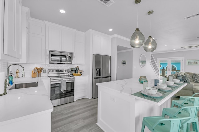 2336 Martinique, Crystal Beach, TX 77650 - kitchen with appliances with stainless steel finishes, a sink, open floor plan, white cabinetry, and recessed lighting