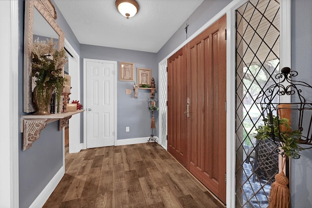 2022 Willow Wisp Dr, Seabrook, TX 77586 - foyer featuring baseboards, dark wood finished floors, and a textured ceiling