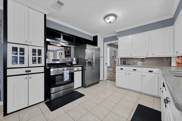 2022 Willow Wisp Dr, Seabrook, TX 77586 - kitchen featuring appliances with stainless steel finishes, light tile patterned floors, white cabinets, decorative backsplash, and crown molding