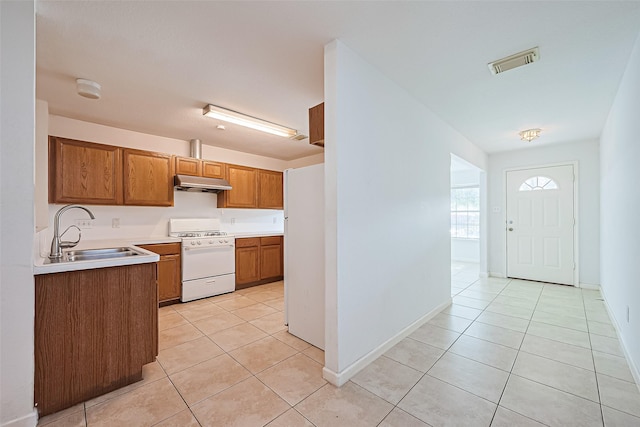 10111 Woodico Ct, Houston, TX 77038 - kitchen with white appliances, a sink, under cabinet range hood, and light tile patterned flooring