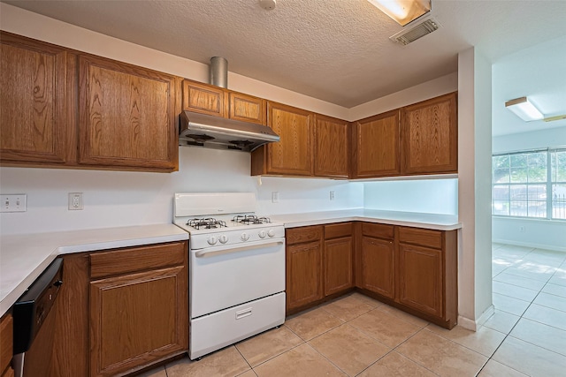 10111 Woodico Ct, Houston, TX 77038 - kitchen with white gas range, under cabinet range hood, brown cabinetry, light tile patterned floors, and light countertops