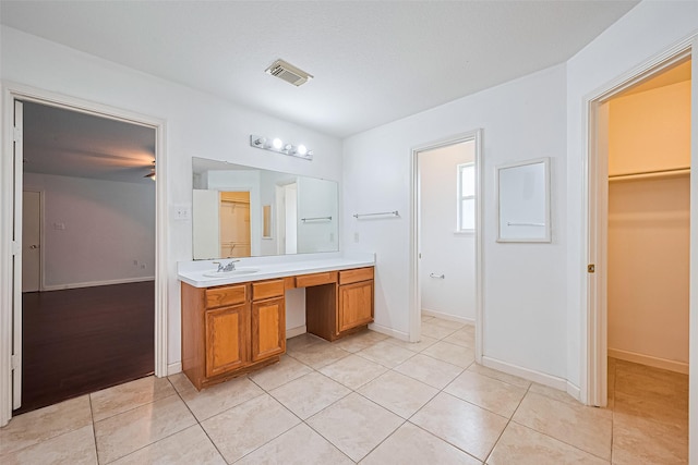 10111 Woodico Ct, Houston, TX 77038 - bathroom with vanity, a spacious closet, tile patterned flooring, and baseboards