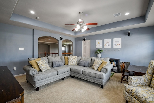 8423 Glenn Leigh Dr NE, Spring, TX 77379 - living area with light colored carpet, a ceiling fan, a tray ceiling, arched walkways, and recessed lighting