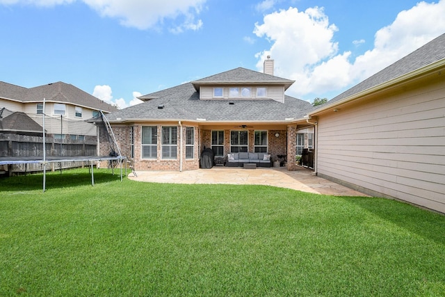 8423 Glenn Leigh Dr NE, Spring, TX 77379 - rear view of house with a trampoline, ceiling fan, a patio, a chimney, and a yard