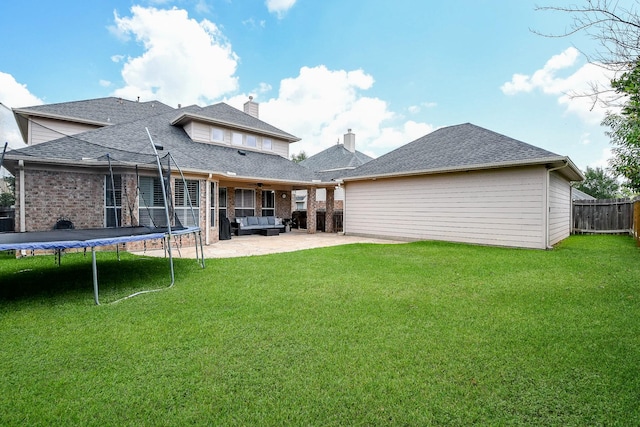 8423 Glenn Leigh Dr NE, Spring, TX 77379 - back of house with a patio, a trampoline, brick siding, and roof with shingles