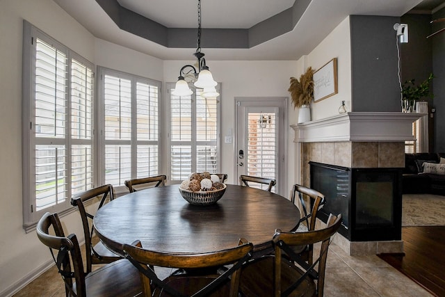 8423 Glenn Leigh Dr NE, Spring, TX 77379 - tiled dining area with a tile fireplace, a tray ceiling, plenty of natural light, and a chandelier