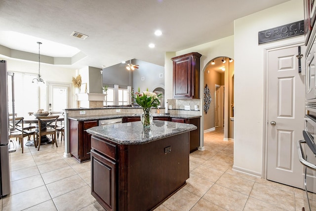 8423 Glenn Leigh Dr NE, Spring, TX 77379 - kitchen with arched walkways, a center island, backsplash, a peninsula, and light tile patterned flooring