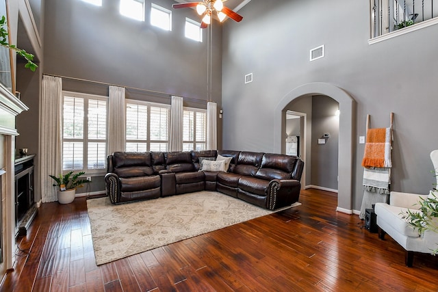 8423 Glenn Leigh Dr NE, Spring, TX 77379 - living area with a ceiling fan, arched walkways, a towering ceiling, a fireplace, and healthy amount of natural light